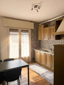 a kitchen with wooden cabinets and a table at Casa Vecellio in Noale
