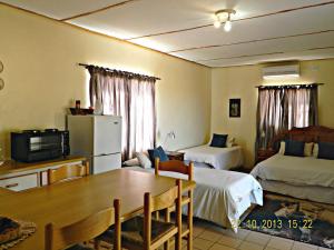 a room with a table and a kitchen with two beds at Vastrap Guest Farm in Grünau