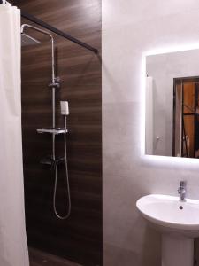 a bathroom with a shower with a sink and a mirror at AL-BUKHARI Boutique Hostel in Bukhara