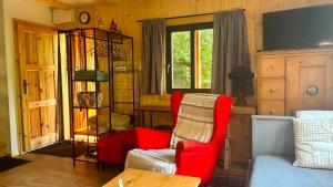 a living room with a red chair and a couch at Chata za dubem in Všelibice