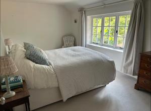 a bedroom with a bed and a window at Riverside Cottage Sleeps 8 with Parking in Marlborough