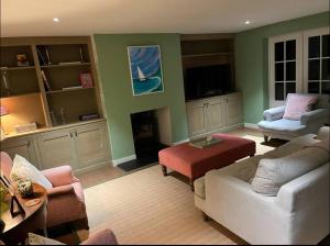 a living room with a white couch and chairs at Riverside Cottage Sleeps 8 with Parking in Marlborough