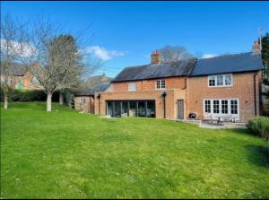 a large brick house with a green yard at Riverside Cottage Sleeps 8 with Parking in Marlborough