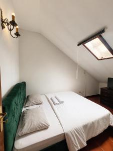 a bed in a room with a green couch at Casa Quixote Matosinhos in São Mamede de Infesta