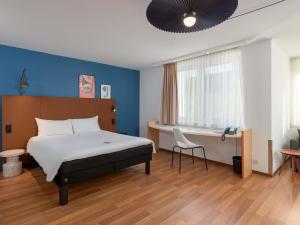 a hotel room with a bed and a desk at ibis Nürnberg Hauptbahnhof in Nuremberg +87 photos
