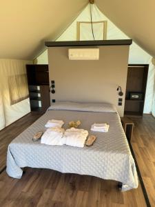 a bedroom with a bed with towels and flip flops on it at simami resort in Caldarola