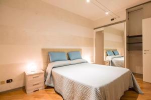 a bedroom with a large white bed with blue pillows at Appartamento Oberdan in Verona