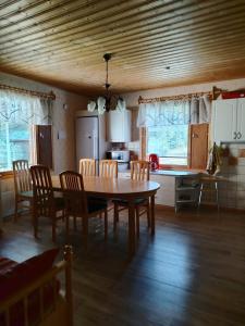 a kitchen with a table and chairs in a room at Lomakoti Tuulensuoja in Kärväsjärvi +45 photos