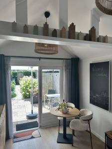a living room with a table and chairs and a patio at Style Gardenhouse Zwanenburg near AMSTERDAM, HAARLEM, ZANDVOORT in Zwanenburg