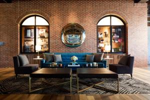 ein Wohnzimmer mit einem blauen Sofa und einer Backsteinwand in der Unterkunft Archer Hotel Tysons in Tysons Corner