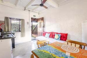 a kitchen and a living room with a table and a couch at Pousada Lua Chalés in Maresias