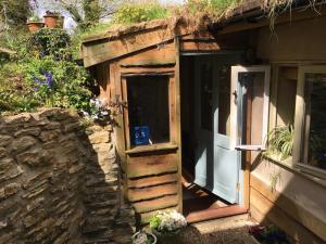 an open door to a building with a stone wall at Pathways, Beachwood Cottage in Bath