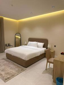 a bedroom with a large bed and a chair at بالم هيلز Palm Hills in Baljurashi +104 photos