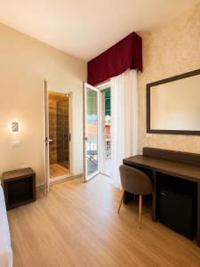 a living room with a desk and a mirror at Hotel Liu in Lido di Camaiore