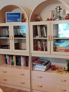 two white cabinets with books and a tv at Lomakoti Tuulensuoja in Kärväsjärvi