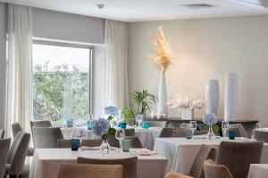a restaurant with white tables and chairs and a large window at Hotel Marad in Torre del Greco +166 photos