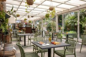 a restaurant with tables and chairs and plants at Hotel Marad in Torre del Greco