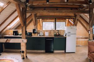 a kitchen with green cabinets and a white refrigerator at Stodoła Baryczy in Postolin