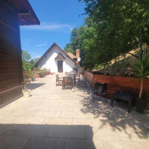 a patio with chairs and tables and a building at Ezüstfenyő Üdülő Visegrád in Visegrád
