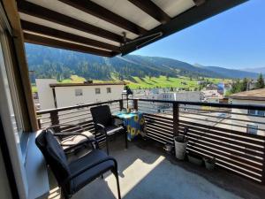 a balcony with two chairs and a table with a view at Davos Swiss Alps in Davos