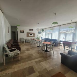 a living room with couches and tables and chairs at Ezüstfenyő Üdülő Visegrád in Visegrád