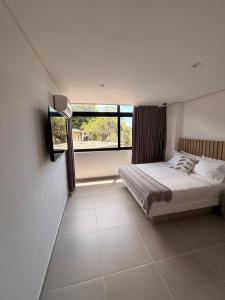 a bedroom with a bed and a large window at Hotel Palmaris Urban Villeta in Villeta