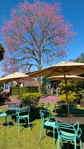 a group of chairs and tables under an umbrella at Vila Francesa Hotel in Penedo