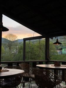 a patio with tables and chairs and a large window at Molfar green 