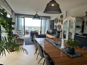 a living room with a large wooden table with chairs at Constantia View Apartments- Luxury Self Catering in Cape Town