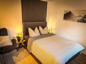 ein Hotelzimmer mit einem Bett und einem Stuhl in der Unterkunft SaaleLoft in Hirschberg
