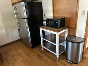 a microwave on a table next to a refrigerator at 4 Room Sleeps 8plus Tranquil Home in Santa Cruz