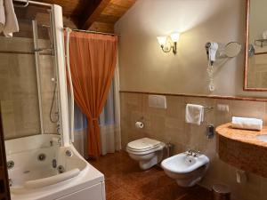 a bathroom with a tub and a toilet and a sink at Le Muse Hotel in San Bonifacio