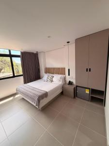 a bedroom with a bed and a large window at Hotel Palmaris Urban Villeta in Villeta +14 photos
