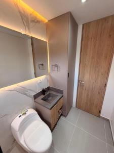 a bathroom with a white toilet and a sink at Hotel Palmaris Urban Villeta in Villeta