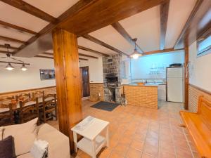 a kitchen and living room with wooden beams at El balcón de Cotefablo Chalet de Montaña con Jardín y Vistas - Arafita Apartamentos in Gavín