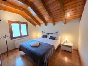 a bedroom with a large bed and wooden ceilings at El balcón de Cotefablo Chalet de Montaña con Jardín y Vistas - Arafita Apartamentos in Gavín