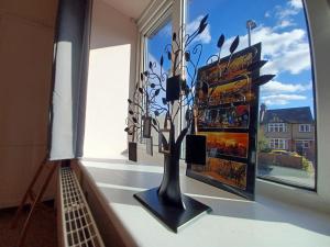 a window with a vase with branches in it at The Pearl Manor in Watford
