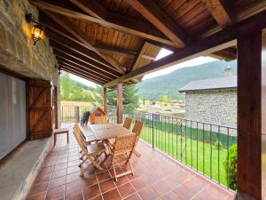 a patio with a table and chairs on a balcony at El balcón de Cotefablo Chalet de Montaña con Jardín y Vistas - Arafita Apartamentos in Gavín