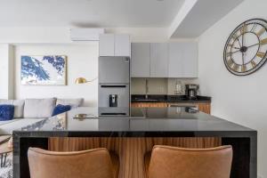 a kitchen with a counter with two bar chairs at Nuevo Vallarta Peaceful Loft in Nuevo Vallarta