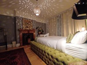 a bedroom with a bed with a couch and a fireplace at The Pearl Manor in Watford