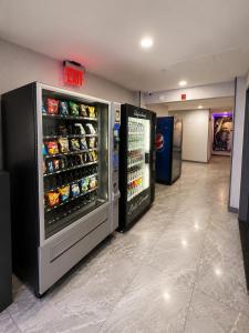 a store aisle with an open refrigerator with drinks at TREMONT HOTEL BRONx-GRAND OPENING in Bronx