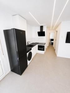 a kitchen with a black refrigerator in a room at ApartamentosCRP in Almería