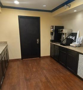 a room with a black door and a coffee maker at Super 10 Fairgrounds, I-40, Airport in Oklahoma City