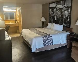 a hotel room with a large bed and a bathroom at Super 10 Fairgrounds, I-40, Airport in Oklahoma City