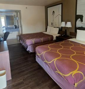 a hotel room with two beds and a table at Super 10 Fairgrounds, I-40, Airport in Oklahoma City
