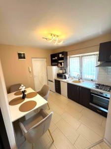a kitchen with a table and chairs and a kitchen with a counter at Luxiva Home in Nyíregyháza