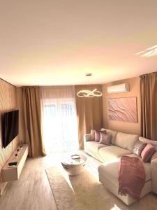 a living room with a couch and a tv at Luxiva Home in Nyíregyháza