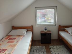 a small bedroom with two beds and a window at Ema in Bajina Bašta