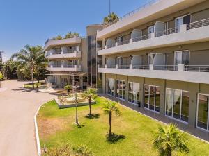 ein Wohnhaus mit Palmen davor in der Unterkunft Amalias Hotel in Kourouta