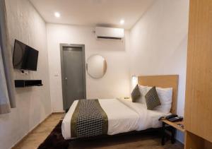 a hotel room with a bed and a television at Hotel A P S Townhouse in Prayagraj